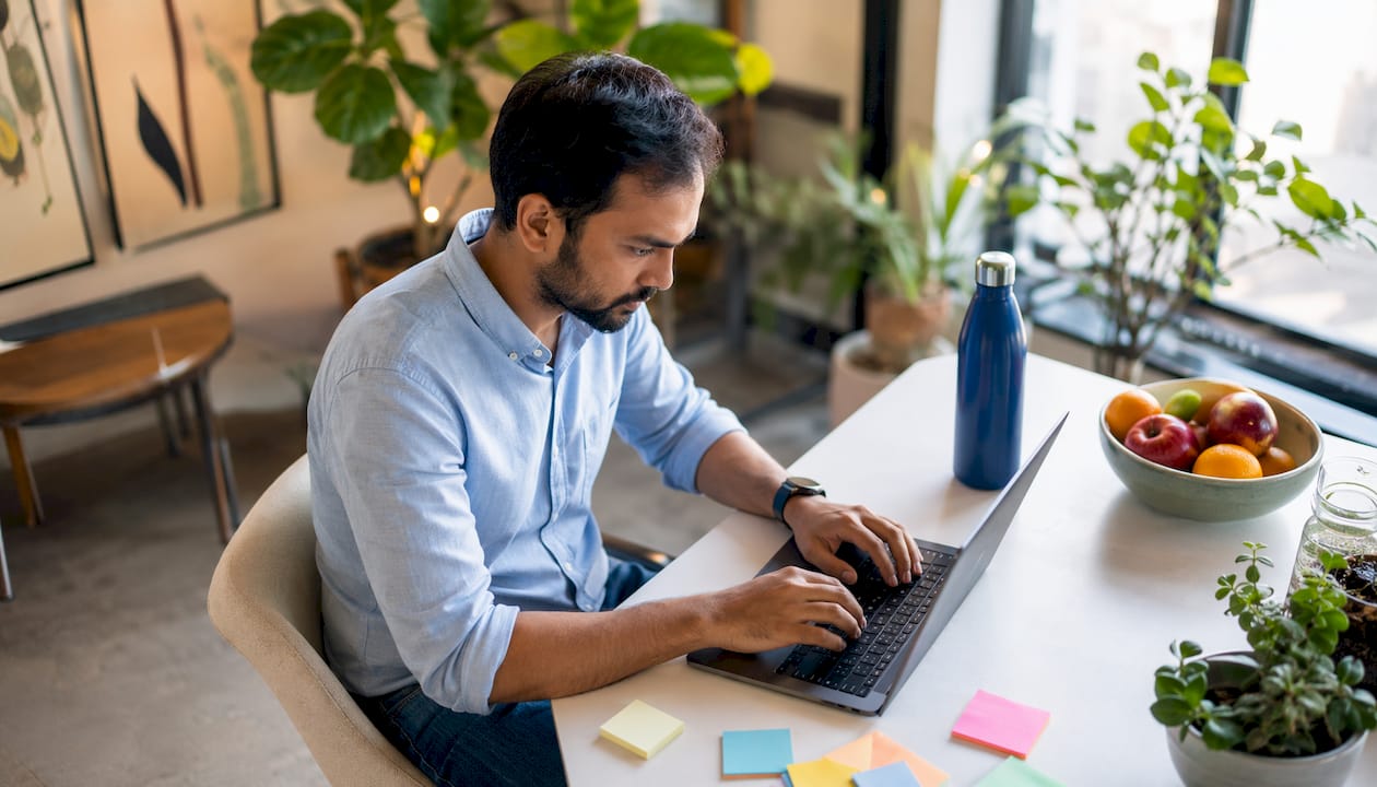 Engineer typing code at desk in home office