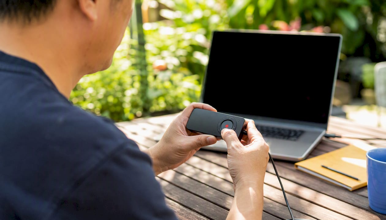 Hands pressing record button on device