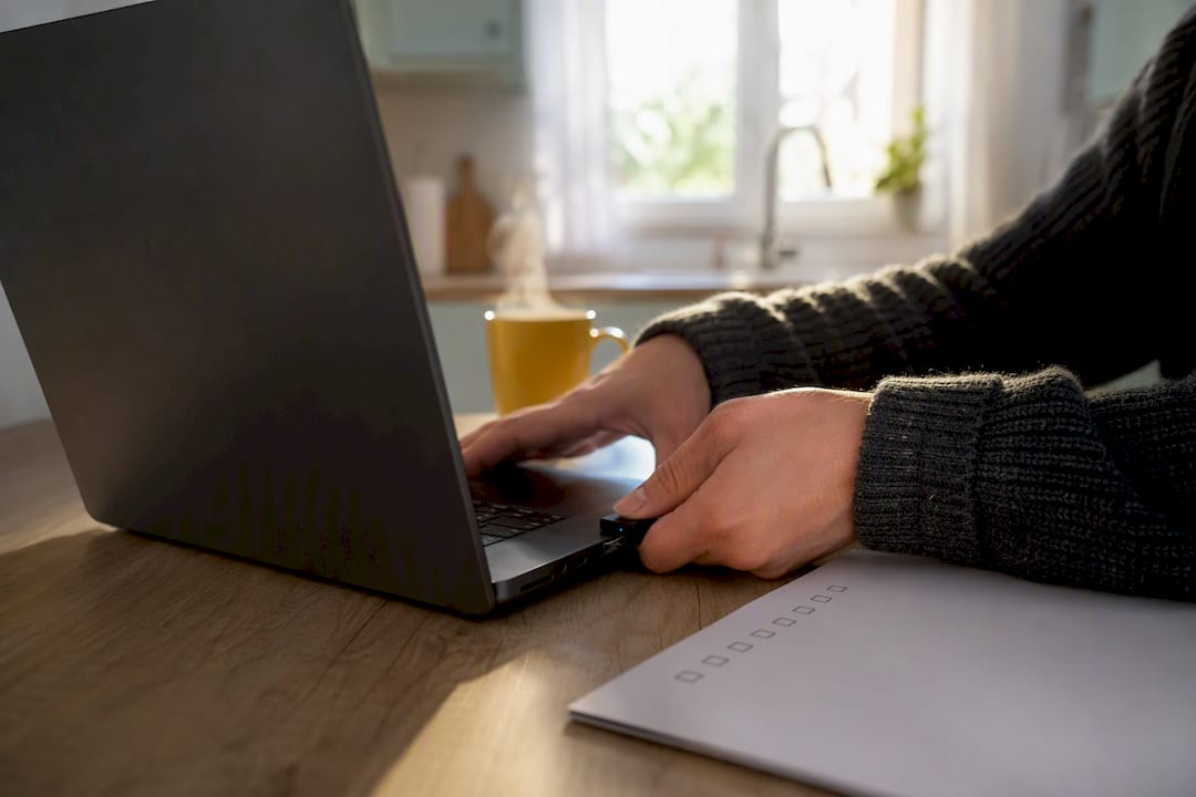 Hands plugging wireless microphone into laptop on office table
