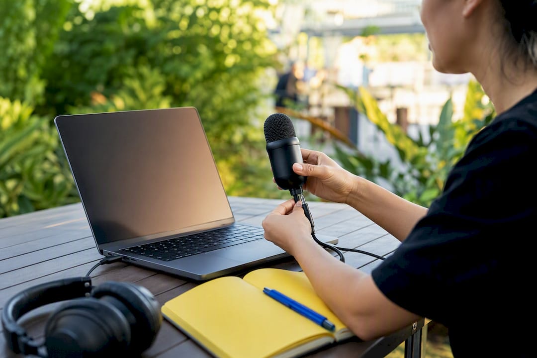 Hands starting recording on laptop in tech workspace